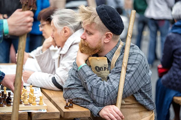 Moscou, Rússia - 11 de setembro de 2016: a celebração de 869 anos da cidade de Moscou. Reconstrução histórica - um homem de terno zelador dos anos 60 jogando no pátio do xadrez com pensionistas — Fotografia de Stock