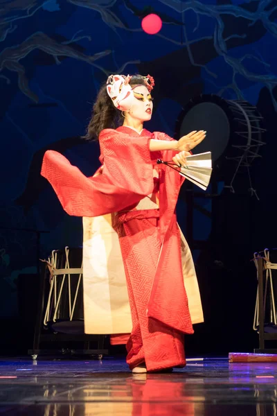 Woman dances with a fan. Traditional Japanese performance red fox dance. Kino Kitsune fox is a character in Japanese legends.