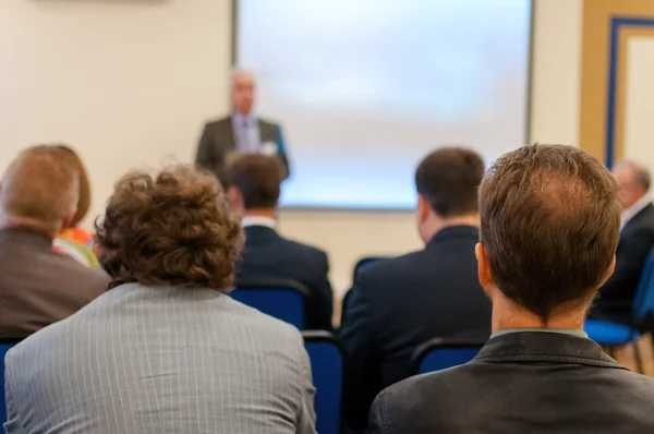 Gente sentada atrás en la conferencia — Foto de Stock