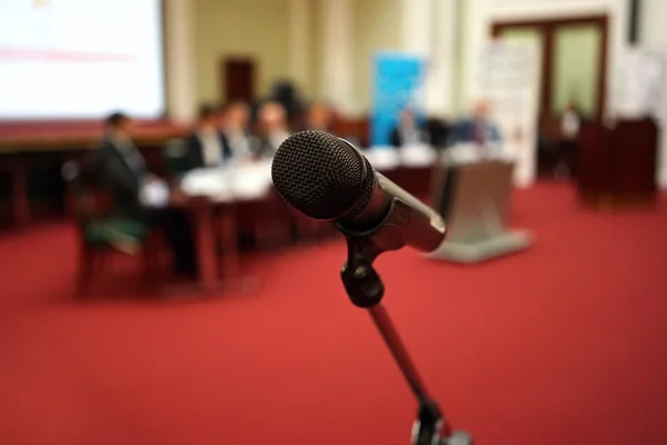 Microphone in focus against blurred audience — Stock Photo, Image