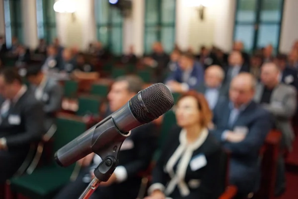 Microphone in focus against blurred audience — Stock Photo, Image