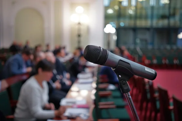 Microphone in focus against blurred audience — Stock Photo, Image