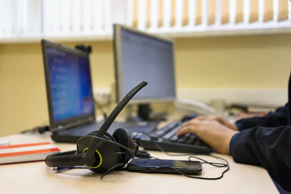 Hoofdtelefoon en pc met handen te typen op het toetsenbord van de computer — Stockfoto