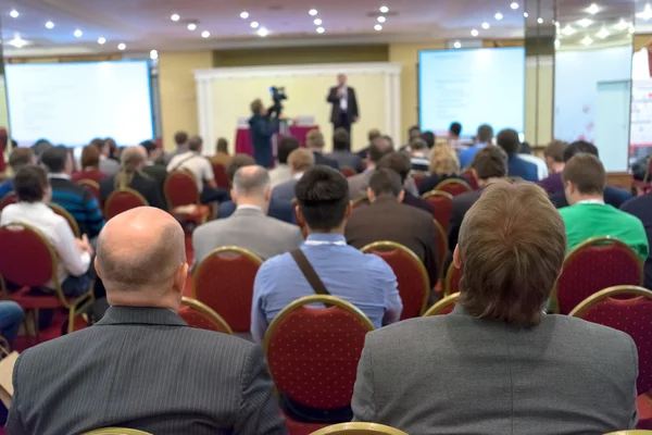 Emberek ülnek a hátsó az üzleti konferencia — Stock Fotó