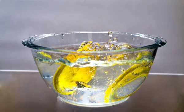 Two lemon slices falling into the water — Stock Photo, Image