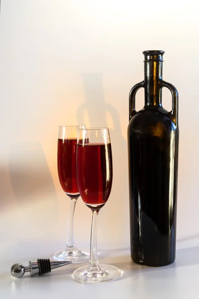 Still life with the original red vine bottle and two wine glasses — Stock Photo, Image