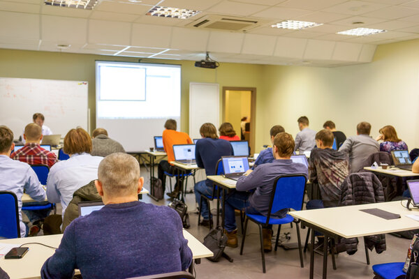 Люди, сидящие сзади на занятиях по компьютерной подготовке
