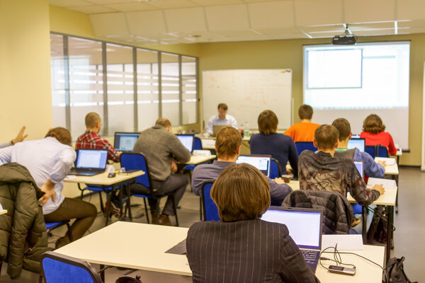 Люди, сидящие сзади на занятиях по компьютерной подготовке
