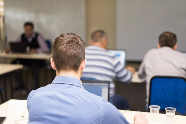Ludzie siedzący tylne na klasę szkolenia komputerowe — Zdjęcie stockowe