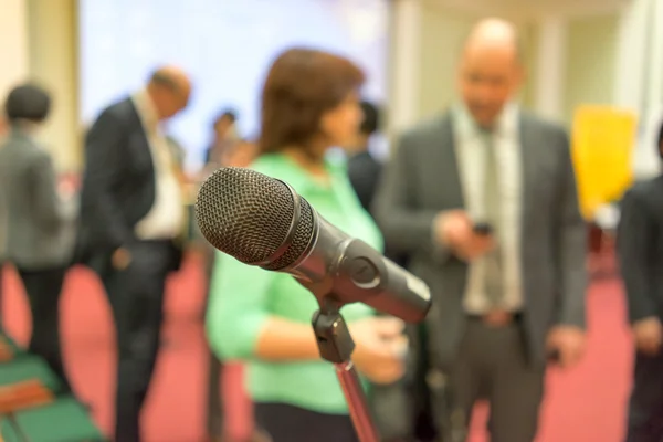 Microphone in focus against blurred audience — Stock Photo, Image