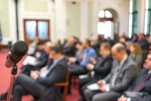 Microphone in focus against blurred audience — Stock Photo, Image