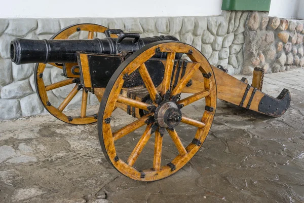 Old medieval artillery canon before a stone wall — Stock Photo, Image