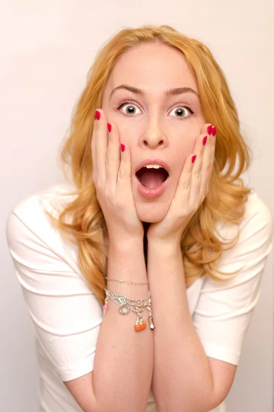 Retrato de cerca de una joven caucusiana con el pelo rubio rizado asustada, asustada y ansiosa. Gritando, con los ojos bien abiertos. Emociones humanas. Parodia en un Munch Scream. Aislado sobre un fondo blanco . —  Fotos de Stock