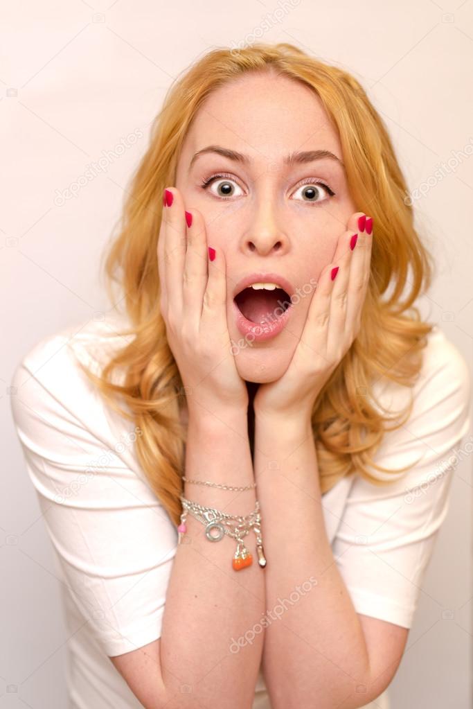 Close up portrait of a young caucusian woman with curly blond hair scared, afraid and anxious. Screaming, with eyes wide open. Human emotions. Parody on a Munch Scream. Isolated on a white background.