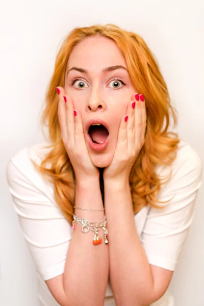 Retrato de cerca de una joven caucusiana con el pelo rizado de jengibre asustada y ansiosa. Gritando con los ojos bien abiertos. Emociones humanas. Parodia en un Munch Scream. Aislado sobre un fondo blanco . —  Fotos de Stock