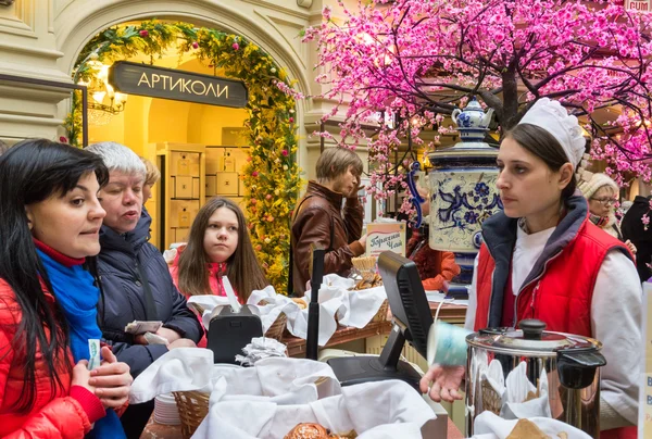 MOSCOW - MARÇO 22: Um comprador que escolhe uma cozedura na loja GUM em 22 de março de 2015 em Moscou. GUM é a grande loja de frente para a Praça Vermelha. É popular entre os turistas internacionais . — Fotografia de Stock