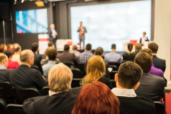 Emberek ülnek a hátsó az üzleti konferencia — Stock Fotó