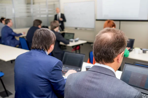 Clases de tutoría y dos hombres sentados en el escritorio escuchando —  Fotos de Stock