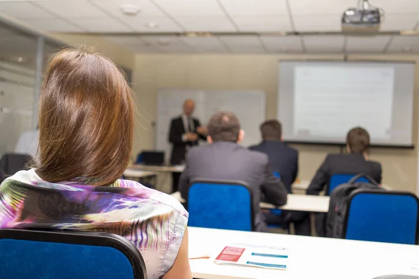 Bakifrån av business folk lyssnar uppmärksamt på konferens. — Stockfoto