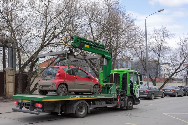 MOSCOW, RÚSSIA - 21 DE ABRIL: Veículo de evacuação leva carro evacuado na rua da cidade. 21 de abril de 2015 — Fotografia de Stock