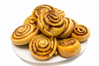 Beyaz arka plan üzerinde izole bir tabak taze tatlı ev yapımı tarçın rulo