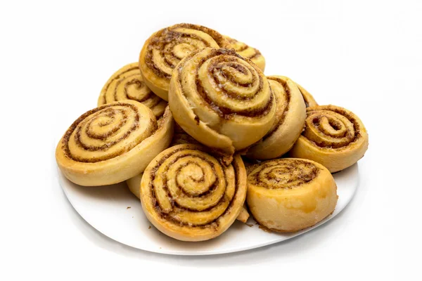 Tasty cinnamon rolls on a dish isolated on white — Stock Photo, Image