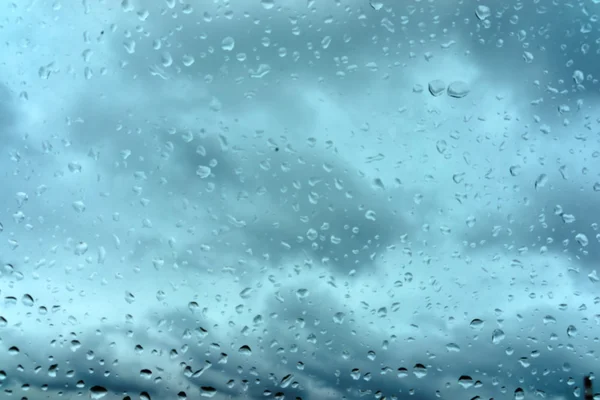 Gotas de chuva no fundo de vidro azul — Fotografia de Stock