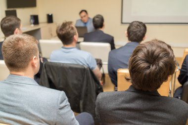 Öğretmen sınıfta dikkatle dinlerken insan arkadan görünüş