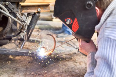 Koruyucu maskeli, kaynak yapan bir işçi.