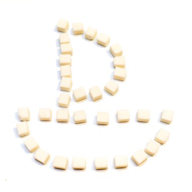 Beyaz arka plan üzerinde kesme şeker yapılmış yelkenli tekne şeklinde