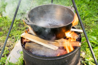 Cooking in a metal pan in a campfire