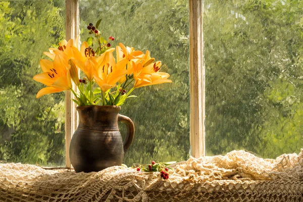 Mazzo di gigli arancioni ibridi asiatici su un davanzale di una finestra in una giornata di pioggia soleggiata. Emozioni di buon umore di colore arancione . — Foto Stock