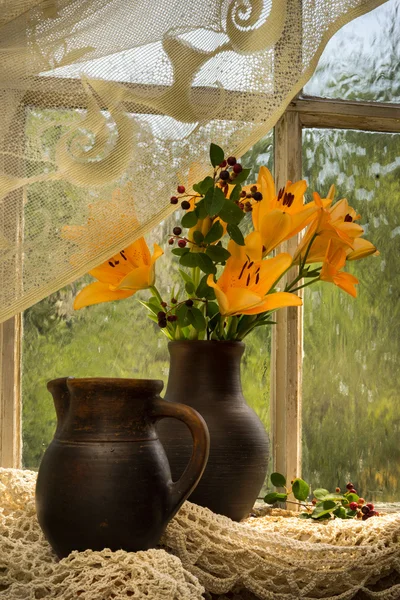 Orange lily bouquet on a window sill — Stock Photo, Image