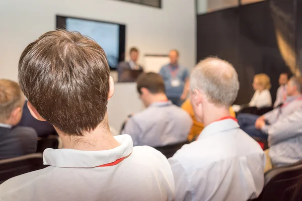 Business seminarium, människor sitter tillbaka och soffan på skärmen agerar presentationen. — Stockfoto