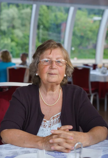Donna anziana positiva al ristorante — Foto Stock