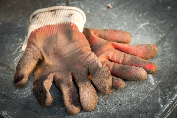 Used dirty gloves on the table — Stock Photo, Image