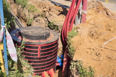 Kazı çukuru, elektrik kabloları ve optik elyaflar kazma bir inşaat sitesinde