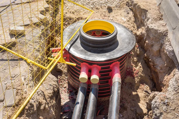 Fosa de excavación, cables eléctricos y fibras ópticas en la excavación en una obra de construcción —  Fotos de Stock