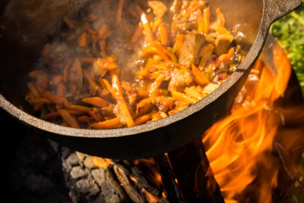 Large pot with pilaf coocing on a fire — Stock Photo, Image