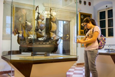 KOTOR, MONTENEGRO - SEPTEMBER 10, 2015: Maritime Museum of Montenegro. Teenager making photo of the vessel model in the museum hall,