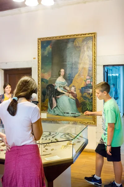 KOTOR, MONTENEGRO - SEPTEMBER 10, 2015: Maritime Museum of Montenegro. Teenagers visitors looking at the exponates in the museum hall — Zdjęcie stockowe