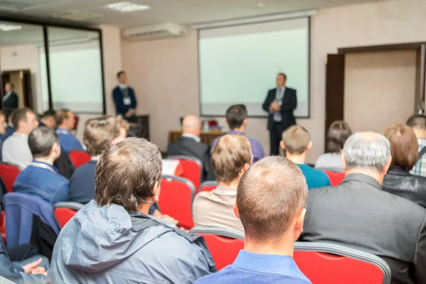 A közönség hallgat az eljáró, a konferencia terem, a két hangszóró a fehér képernyő közelében. — Stock Fotó