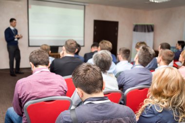Kürsüde hoparlör. Konferans salonundaki insanlar, dikiz aynası