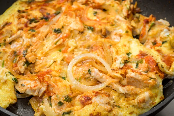 Close up of cooking omelette with onion, tomatoes, chicken and parsley on a frying pan — Stock Photo, Image