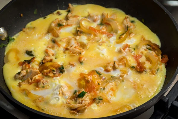 Close up of cooking omelette with onion, tomatoes, chicken and parsley on a frying pan — Stock Photo, Image