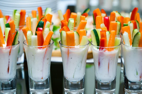 Glasögon med grönsaker snacks på bankettbord — Stockfoto
