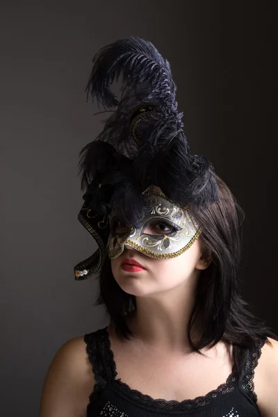 Mujer joven con máscara veneciana sobre fondo gris — Foto de Stock