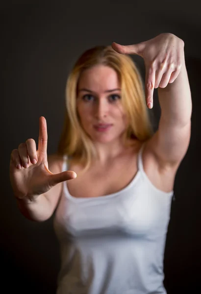 Портрет улыбающейся молодой женщины, делающей раму для рук — стоковое фото