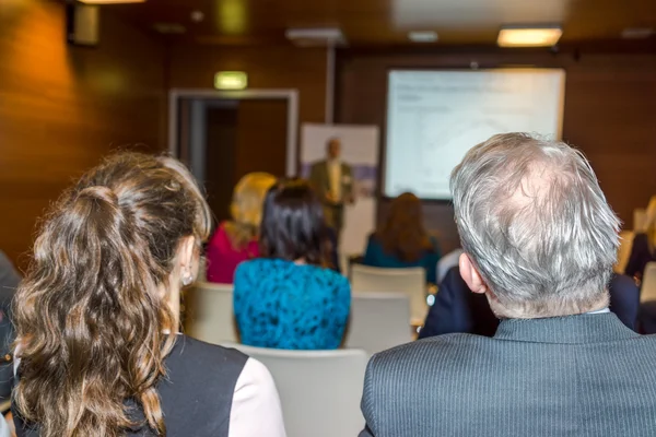 People sitting rear and watching the conference — Stock Photo, Image