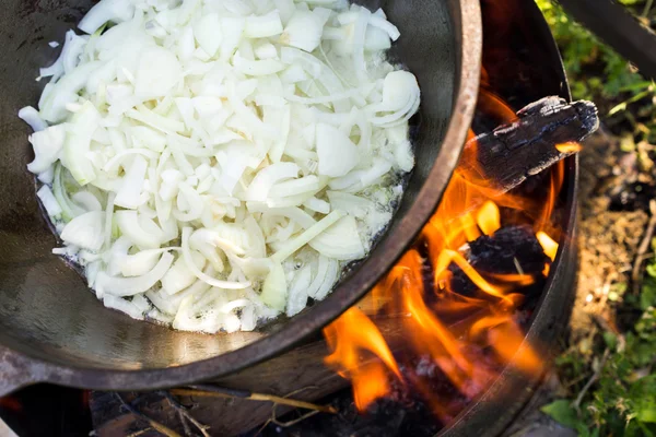 Large pot over a campfire cooking in cast-iron cauldron in nature. Food, Camping, cooking over a fire in the boiler — Stock Photo, Image